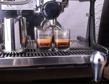 Load image into Gallery viewer, espresso shot glasses under a espresso machine. filled with espresso. shown as a perfect barista tool for coffee interested people, which search for tools for barista
